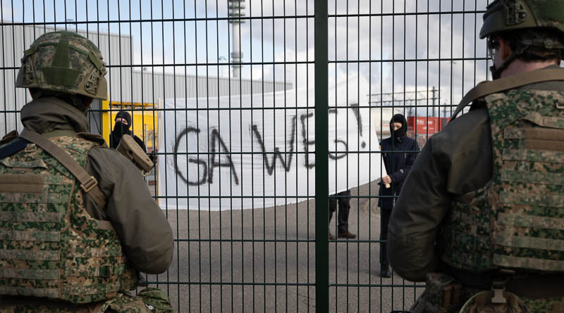 Demonstranten met een spandoek met de tekst 'ga weg'