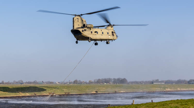 Helikopter vliegt boven een rivier en het water spat op