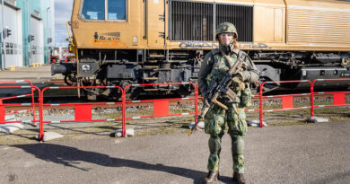 Een militair staat op wacht voor een trein