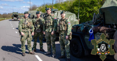 Militairen poseren voor hun voertuig