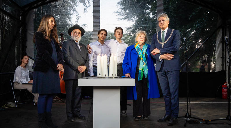 Vijf mensen op rij rondom de kaars
