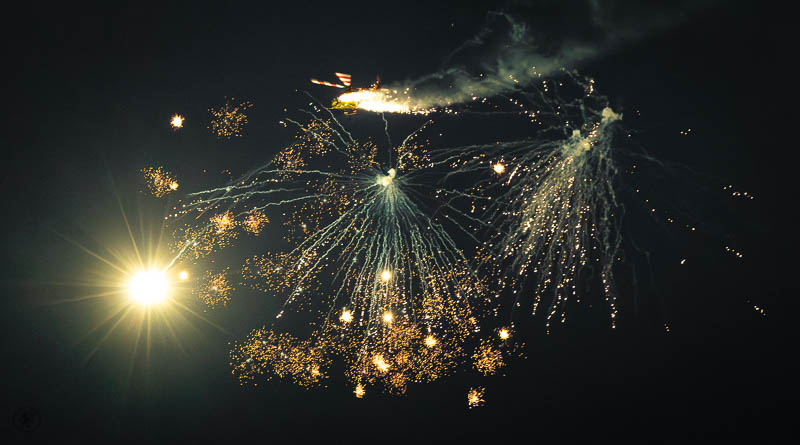 Een helikopter in een donkere lucht die vuurwerk afschiet