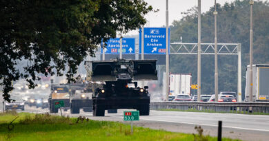 Rupsvoertuigen op een snelweg met op de achtergrond verkeersborden