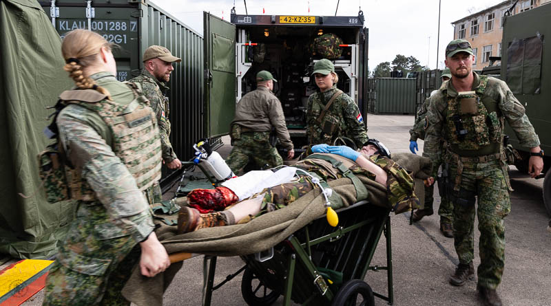 Een gewonde op een brancard wordt uit de ambulance getild.