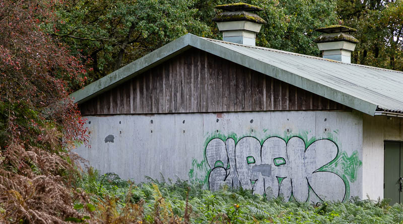 De zijkant van een munitieloods met graffiti