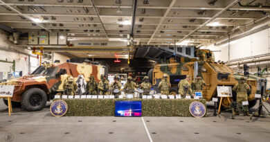 Links en recht voertuigen en daartussen militairen en wapens