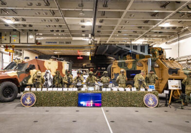 Links en recht voertuigen en daartussen militairen en wapens