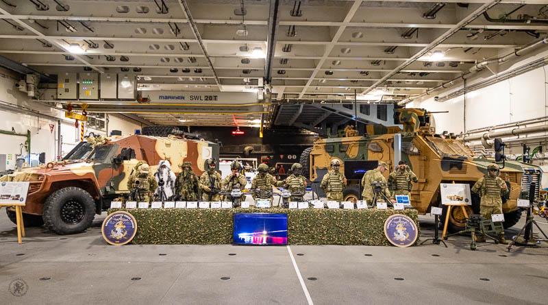 Links en recht voertuigen en daartussen militairen en wapens