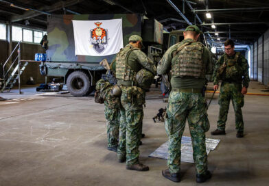 Militairen rond een kaart met op de achtergrond het logo van 434 Herstel