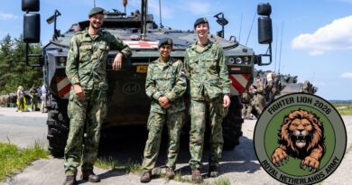 Drie militairen voor een pantservoertuig