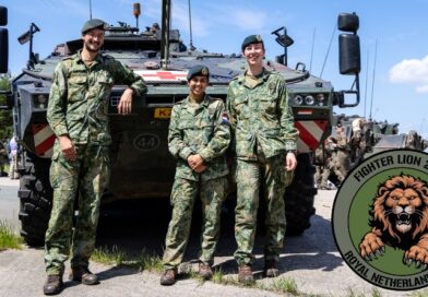 Drie militairen voor een pantservoertuig